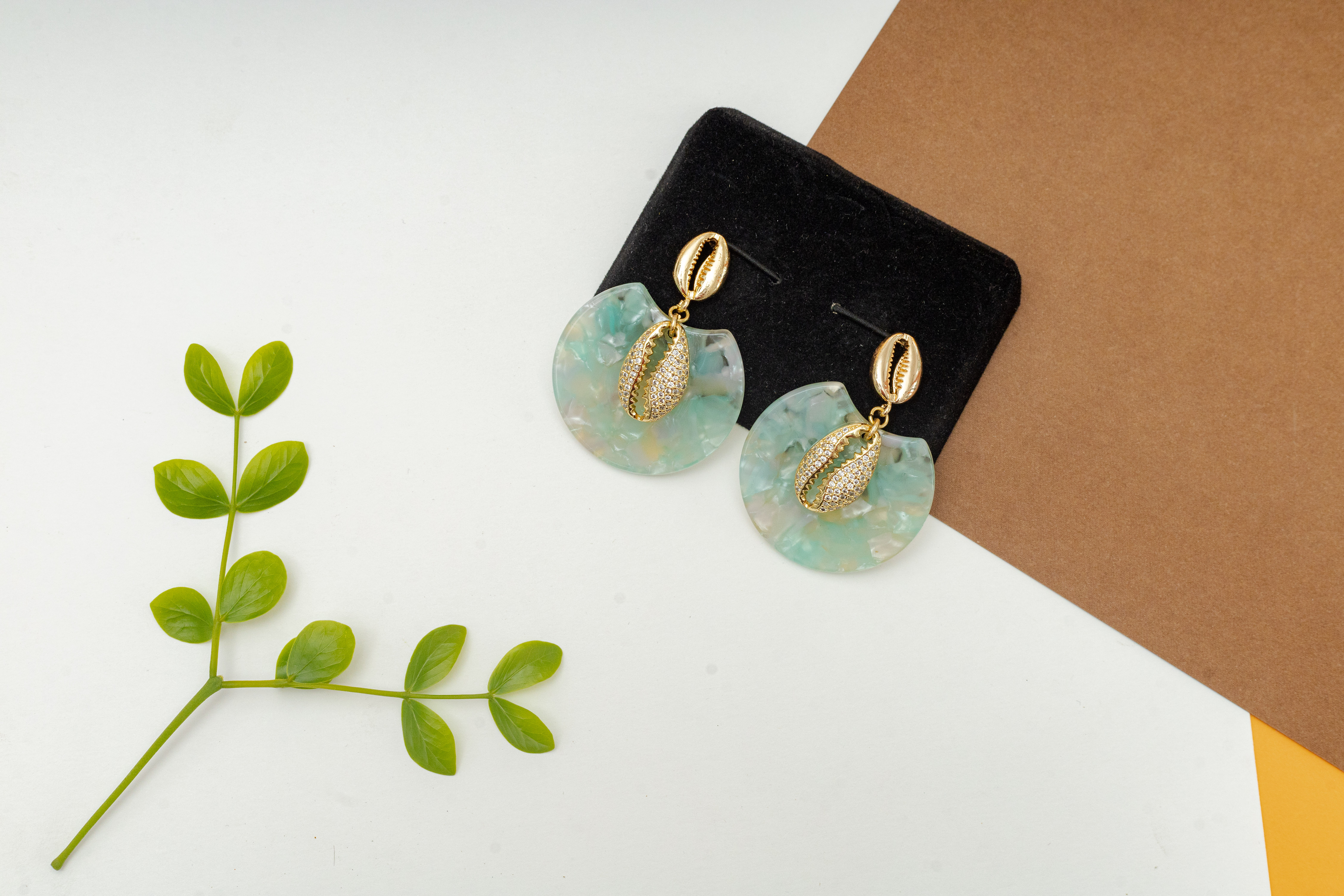 Boucles d'oreilles en résine acrylique et en cauris strass image hover